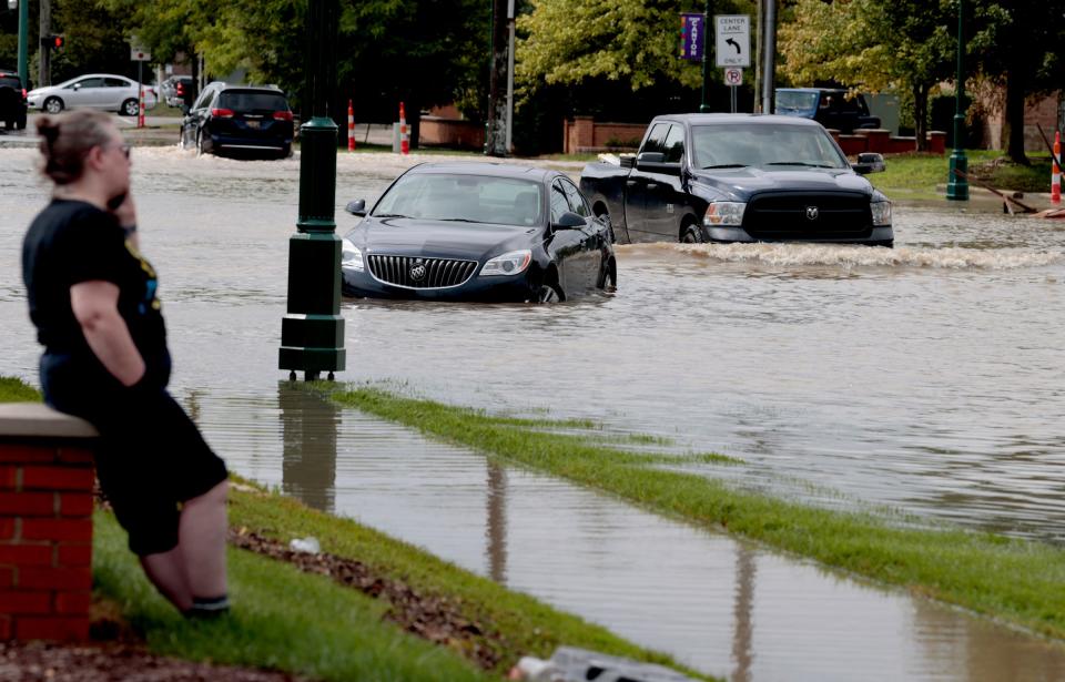 People on their phones and stuck in their cars on a flooded Sheldon Road near Ford Road in Canton after a big thunderstorm dumped several inches of rain in the area in the early morning hours of Thursday, August 24, 2023.