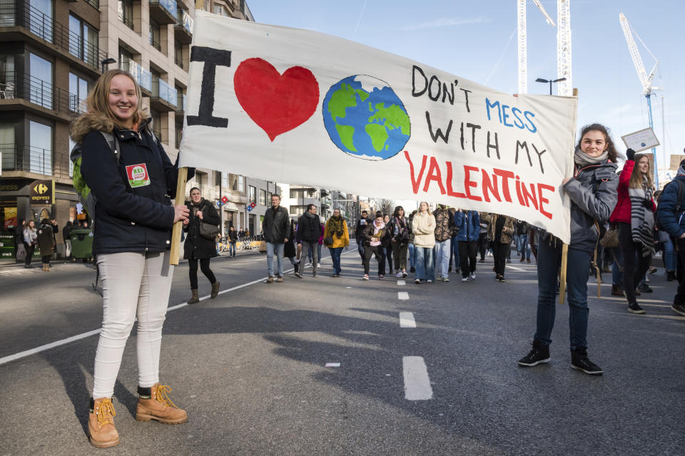 Students pose with a banner during a climate change protest in Brussels, Thursday, Feb. 14, 2019. Thousands of teenagers in Belgium have skipped school for the sith week in a row in an attempt to push authorities into providing better protection for the world's climate. (AP Photo/Geert Vanden Wijngaert)