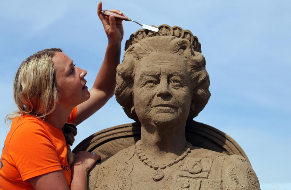 WESTON-SUPER-MARE, ENGLAND - MAY 28: Sand sculpture artist Nicola Wood completes a sand sculpture she has created of Queen Elizabeth II at the annual Weston-super-Mare Sand Sculpture festival on May 28, 2012 in Weston-Super-Mare, England. Now in its seventh year, the festival, which opens to the public on Friday, features sand sculptures from award-winning artists from across the globe. Using 4000 tonnes of Weston beach sand this year's giant sand art display, created by 15 international artists on the theme Fun and Games, runs throughout the summer until September 9. (Photo by Matt Cardy/Getty Images)