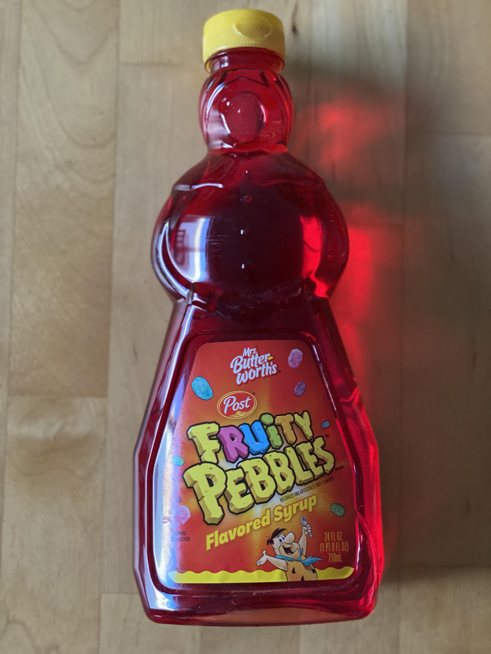 A bottle of Mrs Butterworth's Fruity Pebbles flavored syrup