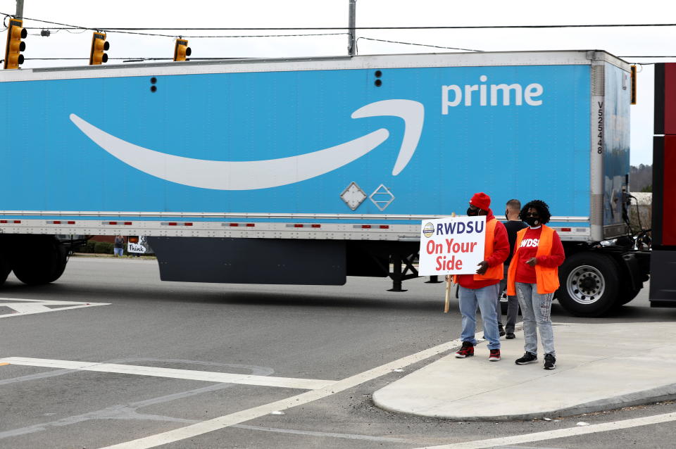 People hold a banner at the Amazon facility as members of a congressional delegation arrive to show their support for workers who will vote on whether to unionize, in Bessemer, Alabama, U.S. March 5, 2021.  REUTERS/Dustin Chambers?