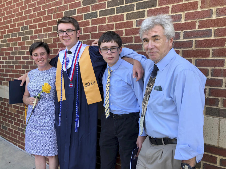In this May 2019, photo provided by Maggie Strom is Ted Strom, right, and from left, Maggie Strom and their sons Kestrel and Pfeiffer at Kestrel's High School Graduation in Memphis, Tenn. Strom, of Germantown, Tenn., was a staff physician at the Memphis Veterans Affairs Medical Center. He was among 34 people who perished when fire swept through the Conception dive boat off the coast of Southern California on Sept. 2, 2019. (Courtesy Maggie Strom via AP)