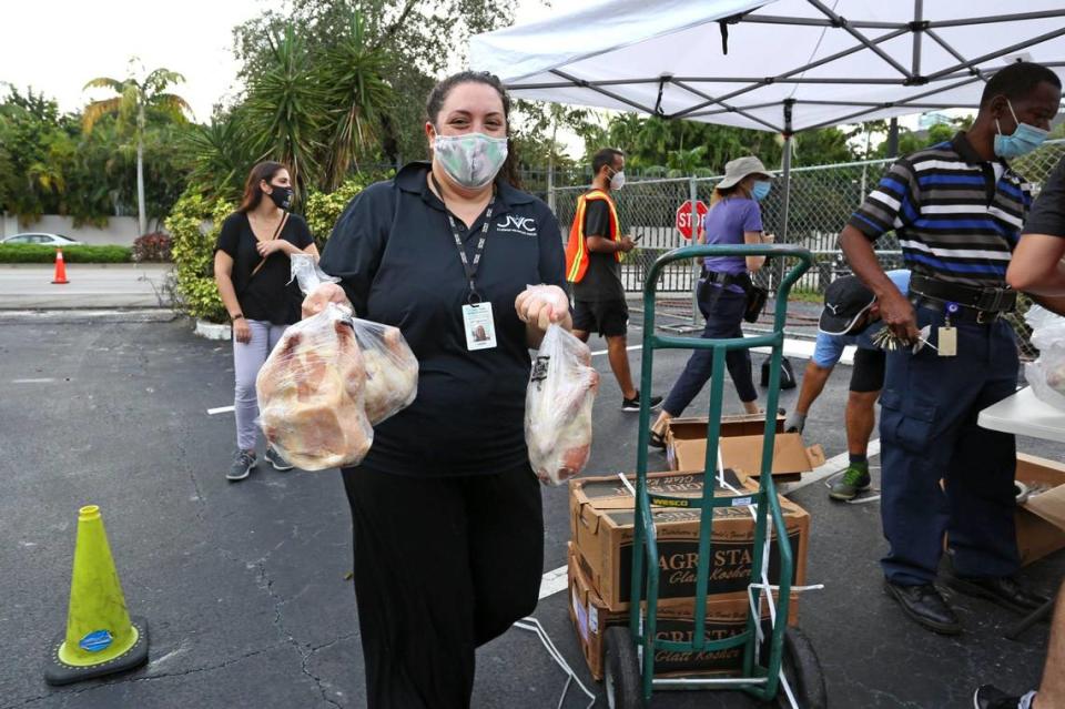 Lori Tabachnikoff, director of the Jewish Volunteer Center, carries frozen chickens during a kosher food distribution event at the Greater Miami Jewish Federation parking lot in response to widespread economic hardship and food insecurity brought on by the COVID-19 pandemic, in Miami, Florida Friday, October 16, 2020.