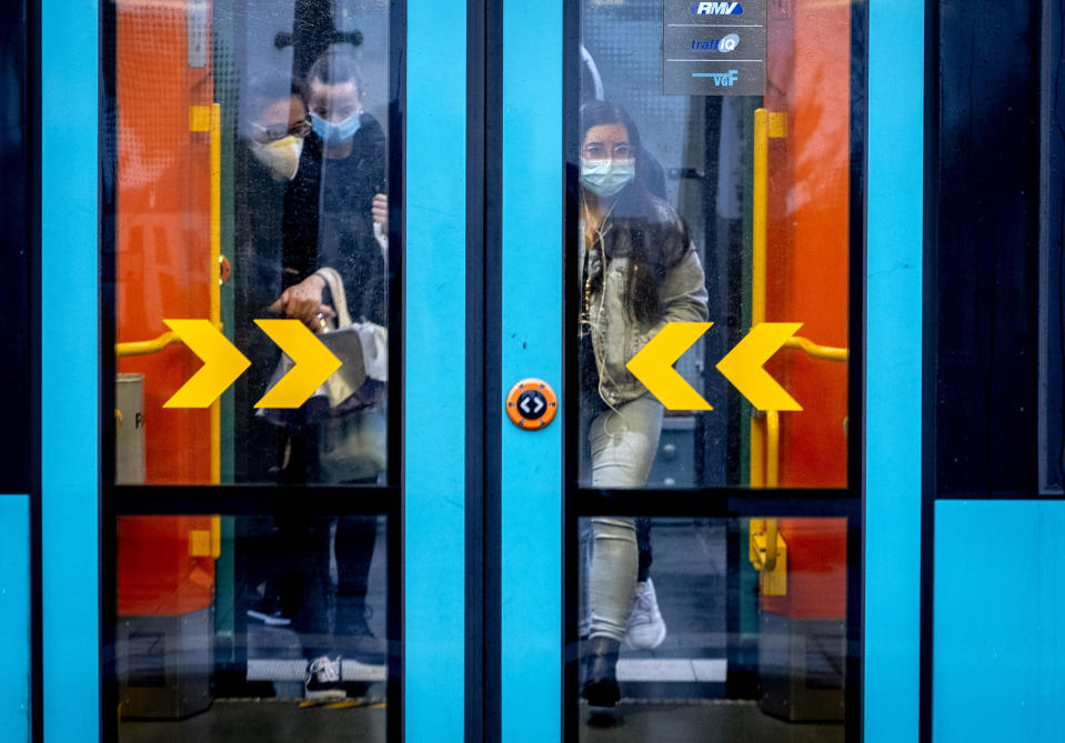 Passengers wear face mask mask as they enter a subway in Frankfurt, Germany, Wednesday, Oct. 28, 2020. (AP Photo/Michael Probst)