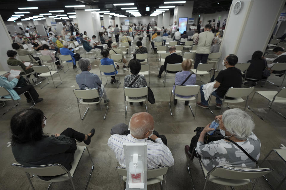 FILE - In this June 6, 2021, file photo, local residents wait for receiving the Moderna coronavirus vaccine at a mass vaccination center in Yokohama, near Tokyo. After months of delays due to political and bureaucratic bungling as well as a shortage of vaccines, inoculations in Japan are taking off, and the drive is now racing down to the wire with the Olympics starting in one month. (AP Photo/Eugene Hoshiko, File)