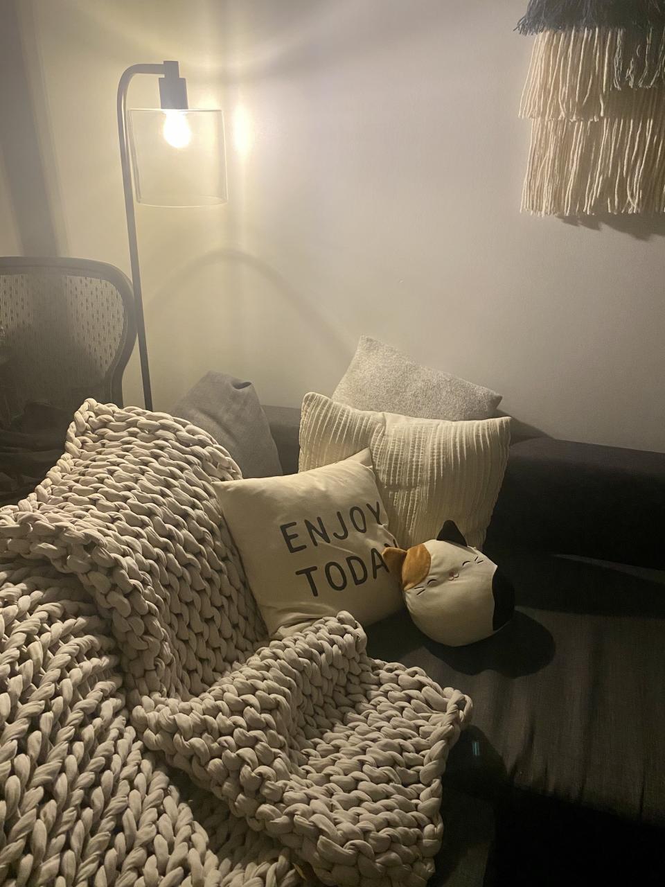 Essentials for a cozy corner: reading lamp, plenty of pillows, and a weighted blanket.