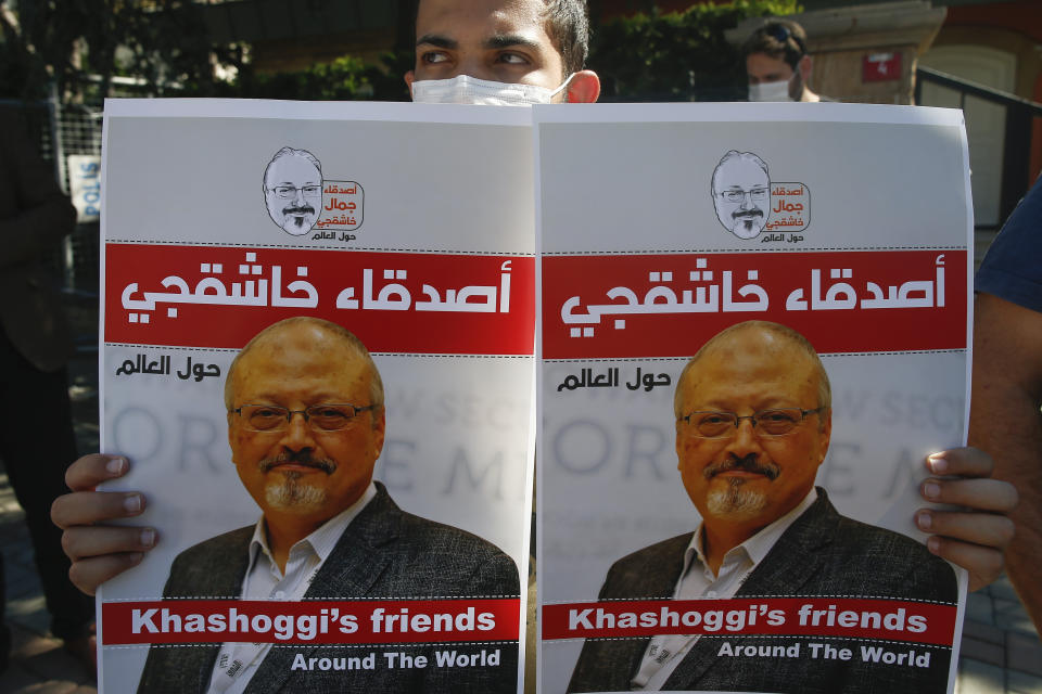 People hold posters of slain Saudi journalist Jamal Khashoggi, near the Saudi Arabia consulate in Istanbul, marking the two-year anniversary of his death, Friday, Oct. 2, 2020. The gathering was held outside the consulate building, starting at 1:14 p.m. (1014 GMT) marking the time Khashoggi walked into the building where he met his demise. (AP Photo/Emrah Gurel)