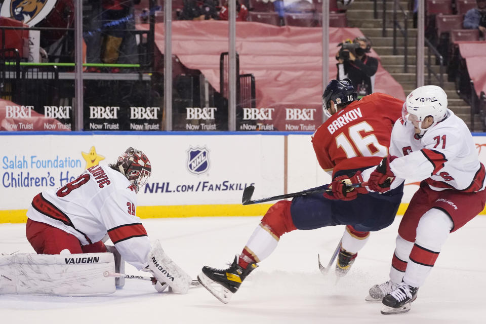 Florida Panthers center Aleksander Barkov (16) attempts a shot at Carolina Hurricanes goaltender Alex Nedeljkovic (39) and right wing Jesper Fast (71) during the second period of an NHL hockey game, Monday, March 1, 2021, in Sunrise, Fla. (AP Photo/Wilfredo Lee)