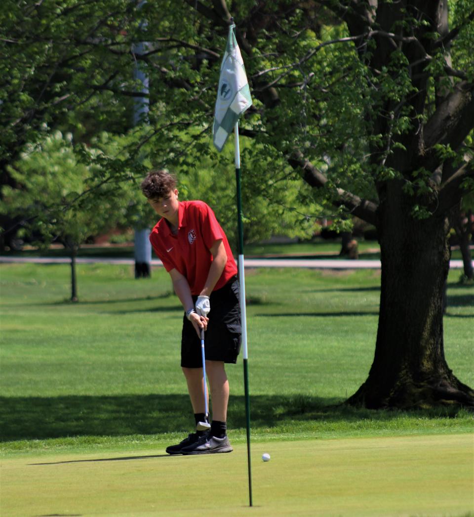 New Boston Huron's Aidan O'Kelley goes for a long putt during the Monroe County Championship Monday.