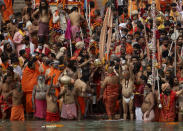 Hindu devotees gather to take holy dips in the Ganges River during Kumbh Mela, or pitcher festival, one of the most sacred pilgrimages in Hinduism, in Haridwar, northern state of Uttarakhand, India, Monday, April 12, 2021. Tens of thousands of Hindu devotees gathered by the Ganges River for special prayers Monday, many of them flouting social distancing practices as the coronavirus spreads in India with record speed. (AP Photo/Karma Sonam)