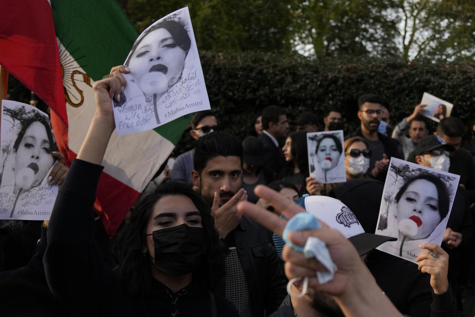 Demonstrators hold placards outside the Iranian Embassy in London, Sunday, Sept. 25, 2022. They were protesting against the death of Iranian Mahsa Amini, a 22-year-old woman who died in Iran while in police custody, who was arrested by Iran's morality police for allegedly violating its strictly-enforced dress code. (AP Photo/Alastair Grant)