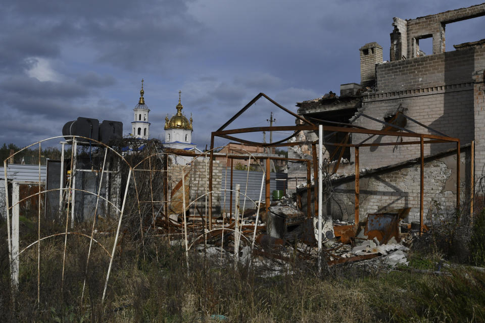 A view of buildings damaged by shelling with an Orthodox Church in the background in the liberated village of Shchurove, Donetsk region, Ukraine, Monday, Nov. 7, 2022. (AP Photo/Andriy Andriyenko)