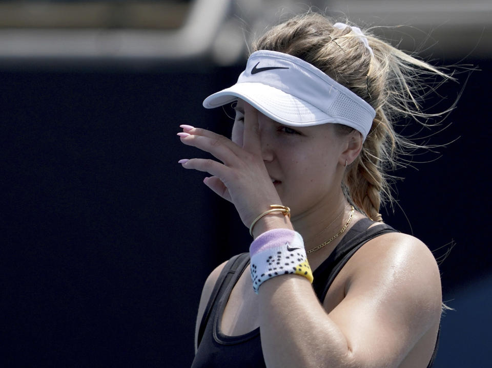 Canada's Eugenie Bouchard wipes the sweat from her face during her women's singles qualifying match against Italy's Martina Trevisan for the Australian Open tennis championship in Melbourne, Australia, Friday, Jan. 17, 2020. (AP Photo/Lee Jin-man)