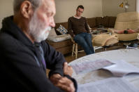 David Tonkin looks over the coroner report on his son, Matthew, as Matthew's friend, Ivo Kinshela, looks on in Perth, Australia, Sunday, July 21, 2019. Kinshela considers David a father figure. He has long been close to the Tonkin family having lived with David and Matthew for three years when he was younger. (AP Photo/David Goldman)