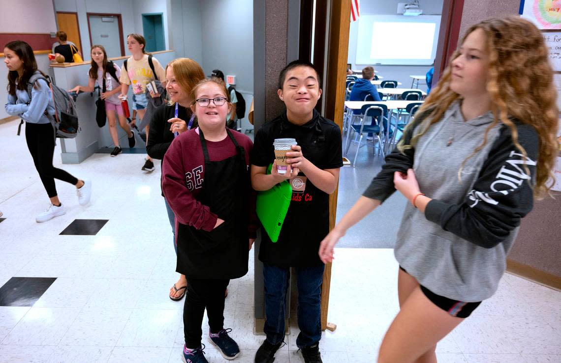 Kate Buerer and Hans Cagabcab wait for the hallway to clear as they deliver a hot chocolate from the Cool Kids Cafe at Goodman Middle School in Gig Harbor, Washington, on Thursday, Sept. 15, 2022.