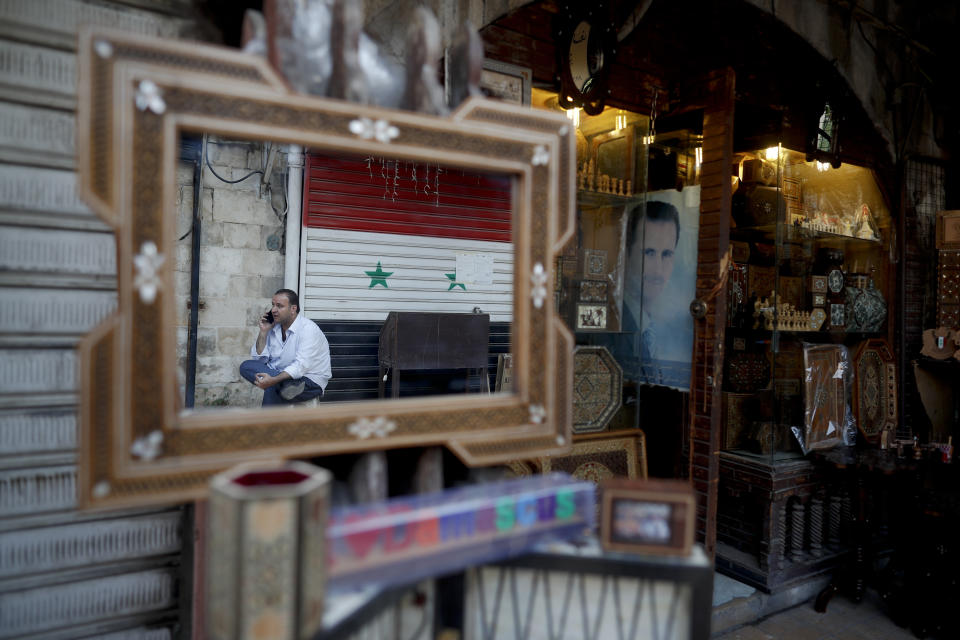 A Syrian shopkeeper waits for customers outside his shop in the Takiyya complex, an ancient construction with landscaped courtyards built on the banks of the Barada River in Damascus, Syria, Wednesday, Oct. 3, 2018. President Bashar Assad told a little-known Kuwaiti newspaper on Wednesday that Syria has reached a "major understanding" with Arab states after years of hostility over the country's civil war. (AP Photo/Hassan Ammar)