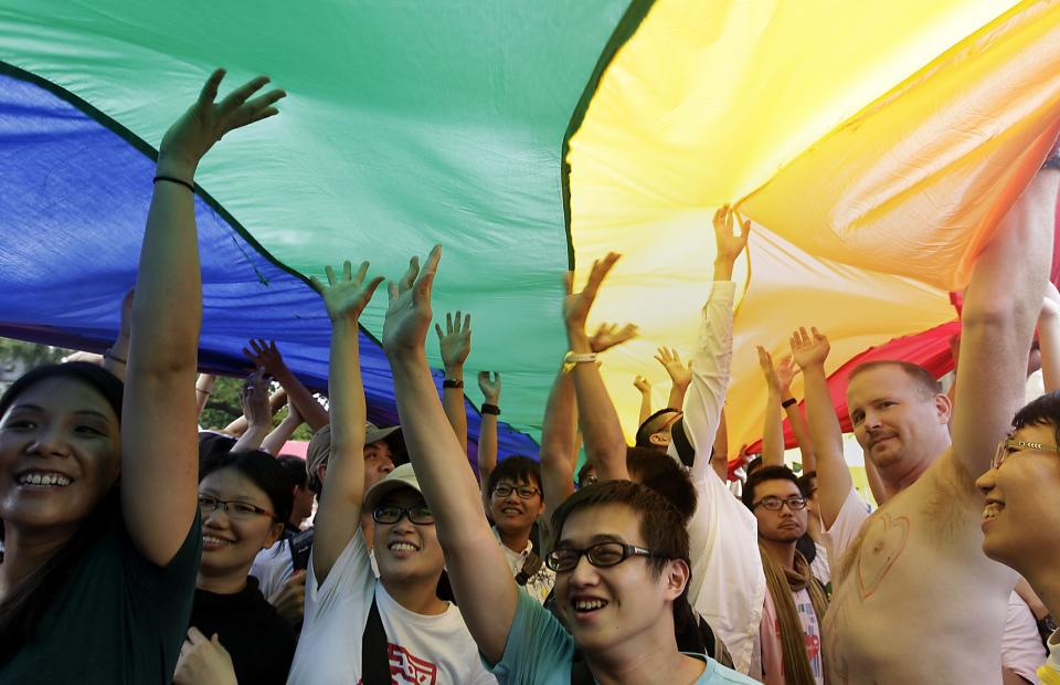 Participants touch a giant rainbow flag during the Taiwan LGBT Pride Parade in Taipei