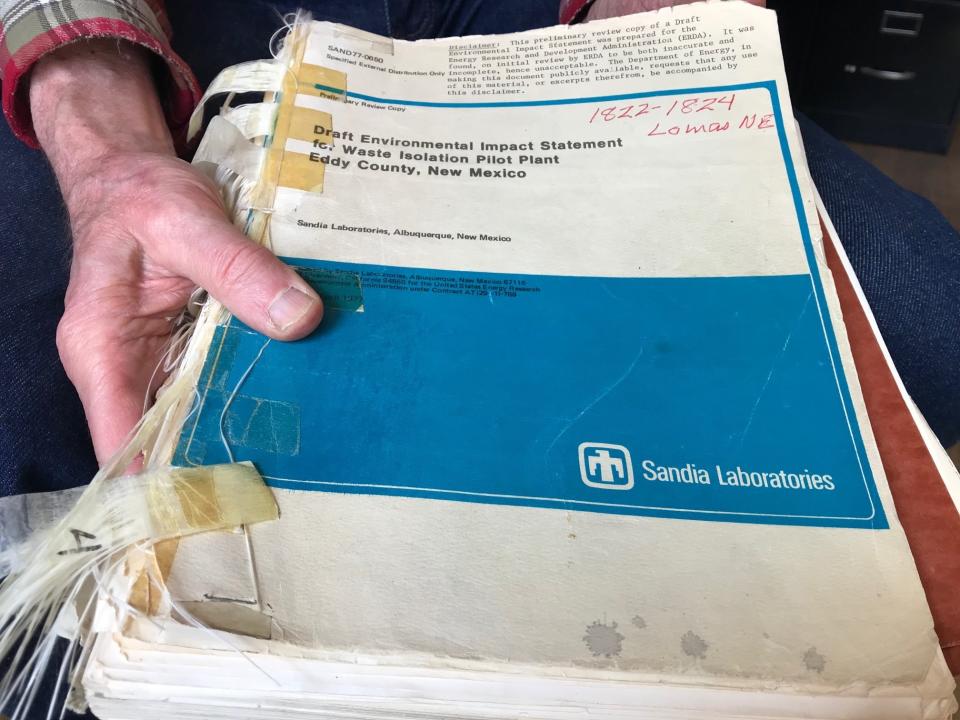 In this March 5, 2019 photo, Don Hancock of the Southwest Research and Information Center holds an early draft copy of an environmental review related to the Waste Isolation Pilot Plant that was planned for southern New Mexico. The underground nuclear repository has been in operation for 20 years, having received its first shipment of waste on March 26, 1999. (AP Photo/Susan Montoya Bryan)