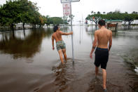 <p>Christian Phillips, 19, (L), and Ilya Hanzli, 17, walk through flooding caused by Hurricane Lane in Hilo, Hawaii, Aug. 25, 2018. (Photo: Terray Sylvester/Reuters) </p>