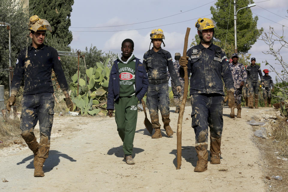 Jordanian rescue teams search Saturday, Nov. 10, 2018 for missing people in the Madaba area, south of the capital of Amman, after flash floods unleashed by heavy rain a day earlier killed at least 12 people. (AP Photo/Raad Adayleh)