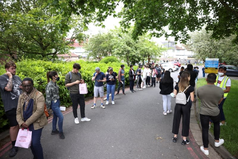 People queue outside a vaccination centre for those aged over 18 at the Belmont Health Centre in Harrow, amid the coronavirus disease (COVID-19) outbreak, in London