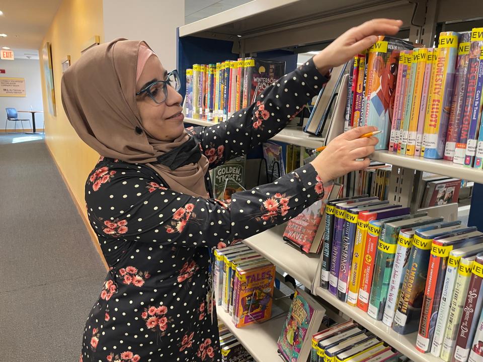 Fatima Es-Slaoui Collins, a library assistant in the children’s department at Otis Library, shelving books. Muslims see Ramadan as a sacred time to get closer to God, with a celebratory end of the month with  Eid Al-Fitir, as friends and family visit and children get new clothes, she said.