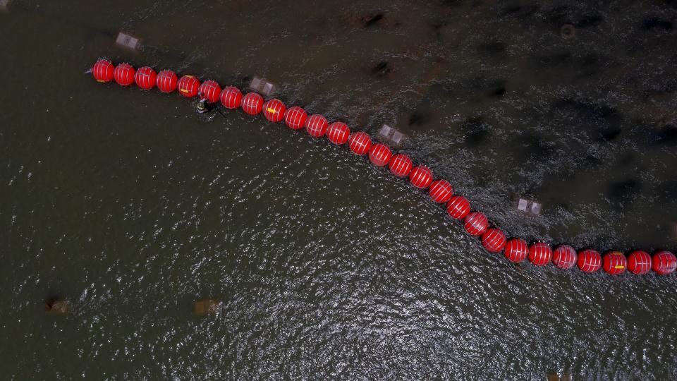 Buoys float on the Rio Grande River in Eagle Pass, Texas on July 20, 2023, as a Mexican engineer with the International Boundary and Water Commission uses GPS determine to see if the buoys are crossing into Mexican territory. The buoys were installed on orders by Texas Governor Greg Abbott as an obstacle to prevent migrants from reaching the north embankment of the Rio Grande on the international boundary between Mexico and the U.S.