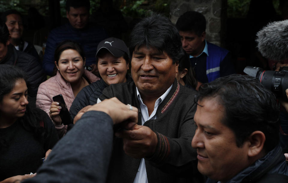 Bolivia's President Evo Morales, center, greets supporters during a visit to a trout farm where he stopped to eat, in Incachaca, Bolivia, Saturday, Oct. 19, 2019. Morales is seeking a fourth term in Sunday's general elections. (AP Photo/Juan Karita)