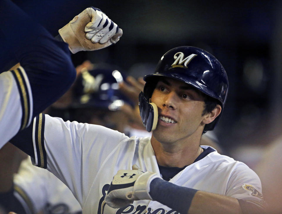 FILE - In this Monday, Sept. 17, 2018 file photo, Milwaukee Brewers' Christian Yelich is congratulated by teammates in the dugout after hitting a two-run home run during the fifth inning of a baseball game against the Cincinnati Reds in Milwaukee. Milwaukee outfielder Christian Yelich was a runaway winner for the National League Most Valuable Player award after helping the Brewers return to the playoffs for the first time in seven years. Yelich received 29 first-place votes and 415 points from the Baseball Writers' Association in balloting announced Thursday, Nov. 15, 2018. (AP Photo/Aaron Gash, File)