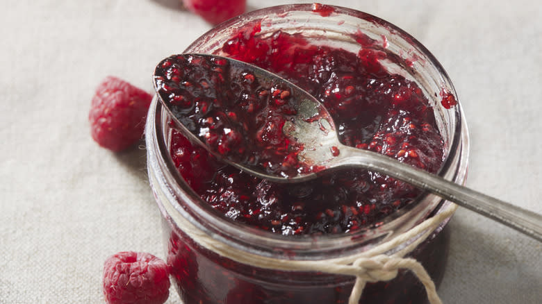 Open raspberry jam glass jar