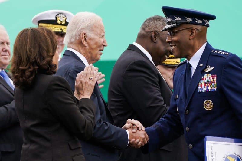 Vice President Kamala Harris (left) applauds as President Biden (center) shakes hands with incoming Joint Chiefs of Staff Chairman General Charles Q. Brown, Jr. during a ceremony at Joint Base Myer-Henderson Hall, Arlington, Virginia on Friday. Photo by Nathan Howard/UPI