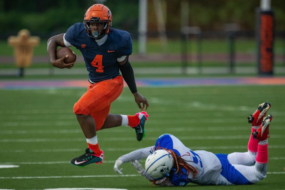 Chauncey Bowens (4) escapes a tackle by Marvin Curry (5) as The Benjamin School Buccaneers hosted the Pahokee Blue Devils in boys high school football at the school in Palm Beach Gardens, Fla., on October 13, 2023. Bowens scored a first quarter rushing touchdown for the Bucs.