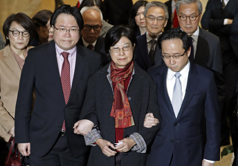 Selina Tsang, center, wife of former Hong Kong leader Donald Tsang, is accompanied by her two sons, Simon Tsang Hing-yin, left, and Thomas Tsang Hing-shun, to walk out of the High Court in Hong Kong, Wednesday, Feb. 22, 2017. The former leader of Hong Kong was sentenced Wednesday to 20 months in prison for misconduct after failing to disclose plans to rent a luxury apartment for his retirement from a businessman applying for a broadcasting license. (AP Photo/Kin Cheung)