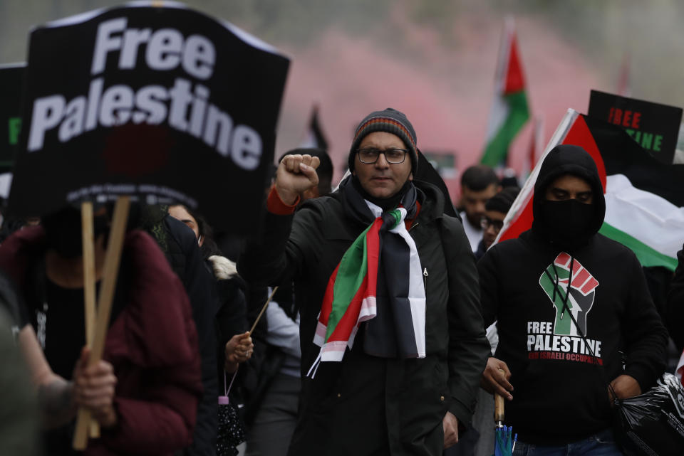 Protesters hold placards and banners in London, Saturday, May 22, 2021, as they take part in a rally supporting Palestinians. Egyptian mediators held talks Saturday to firm up an Israel-Hamas cease-fire as Palestinians in the Hamas-ruled Gaza Strip began to assess the damage from 11 days of intense Israeli bombardment. (AP Photo/Alastair Grant)