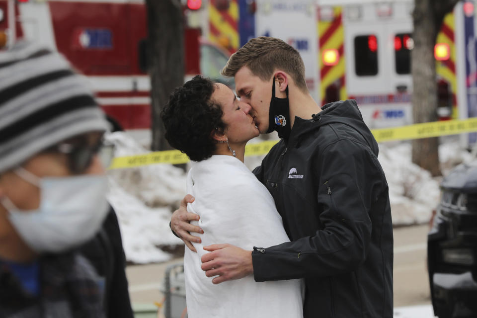 A couple kiss in the wake of a mass shooting at a King Soopers supermarket in Boulder.