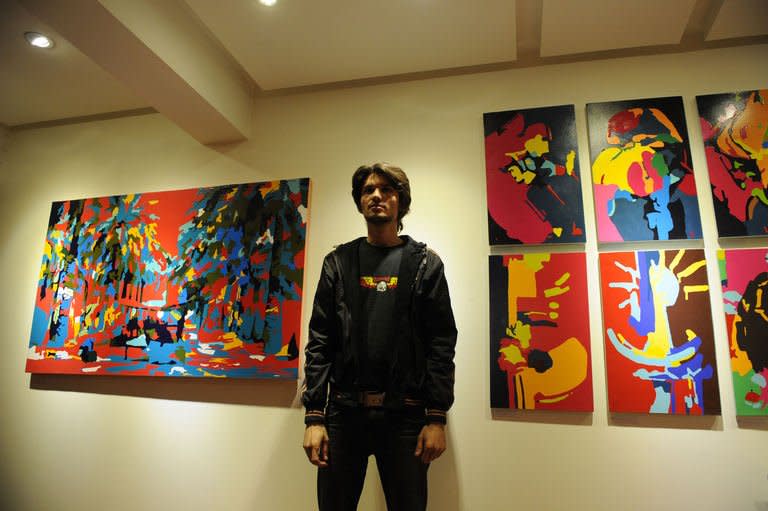 Pakistani artist Qadir Jhatial poses with his paintings during an exhibition at the Rohtas Art Gallery in Islamabad, December 12, 2012. It may not seem the most obvious setting, but a squat building overlooking a slum is home to one of Pakistan's leading galleries, which for 30 years has defied dictatorships and fundamentalists to champion cutting-edge art
