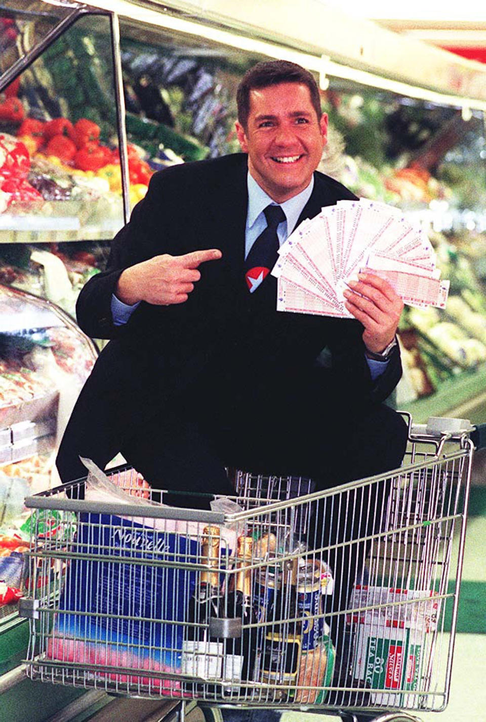 Dale Winton doing a ‘Supermarket Sweep’ in Brent Cross, London, to promote the midweek National Lottery, in 1997. (PA)