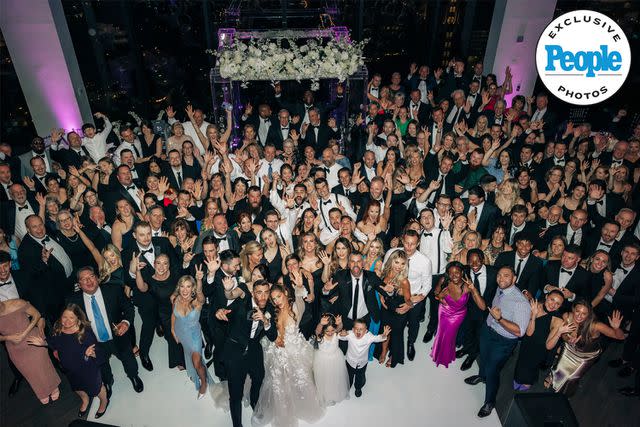 <p>Ella Farrell Photography </p> Ashley and Matt Turner pose for a photo with all of their wedding guests