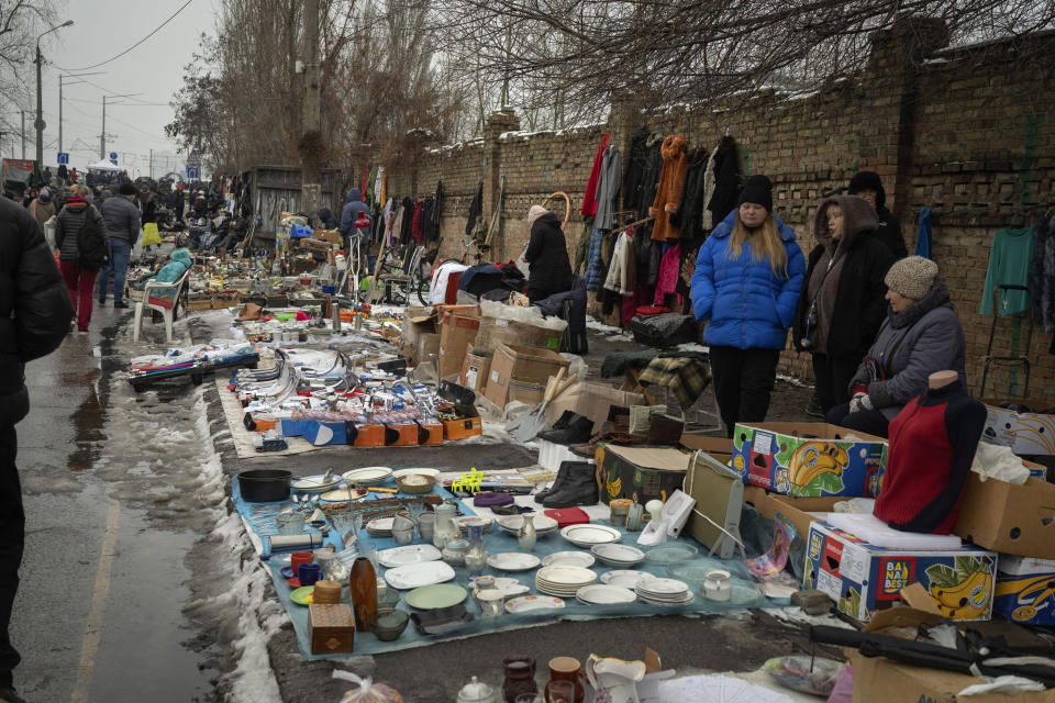 People sell objects at a city flea market in Ukraine's capital Kyiv, Sunday, Feb. 11, 2024. Despite more and more buyers having to tighten their belts, the market still offers a large variety of goods as it survived the second year of war with Russia. (AP Photo/Efrem Lukatsky)