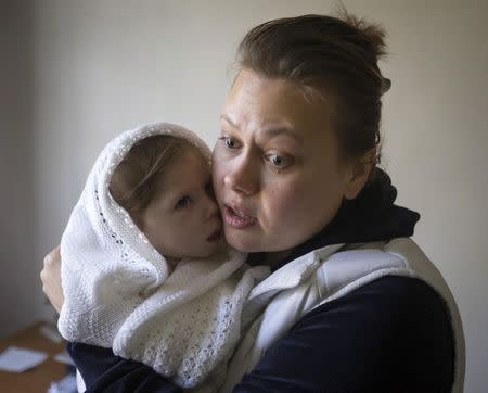 Viktoria holds her daughter Stephanya, aged one year and three months, at a clinic which specialises in children's neurological disorders in Donetsk, eastern Ukraine, October 10, 2014. REUTERS/Shamil Zhumatov