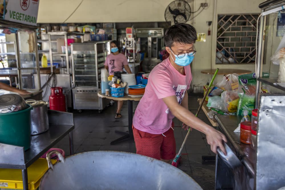 A man cleans up his food stall in a coffeeshop after the enhanced movement control order was lifted in Petaling Jaya Old Town May 21, 2020. — Picture by Shafwan Zaidon