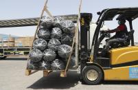 A forklift driver loads material for temporary shelters to be sent to India, at the UNHCR warehouses, part of the International Humanitarian City, in Dubai, United Arab Emirates, Sunday, May 9, 2021. Dubai's long-haul carrier Emirates will begin shipping aid from the World Health Organization and other groups into India for free to help fight a crushing outbreak of the coronavirus, the airline said Sunday. (AP Photo/Kamran Jebreili)