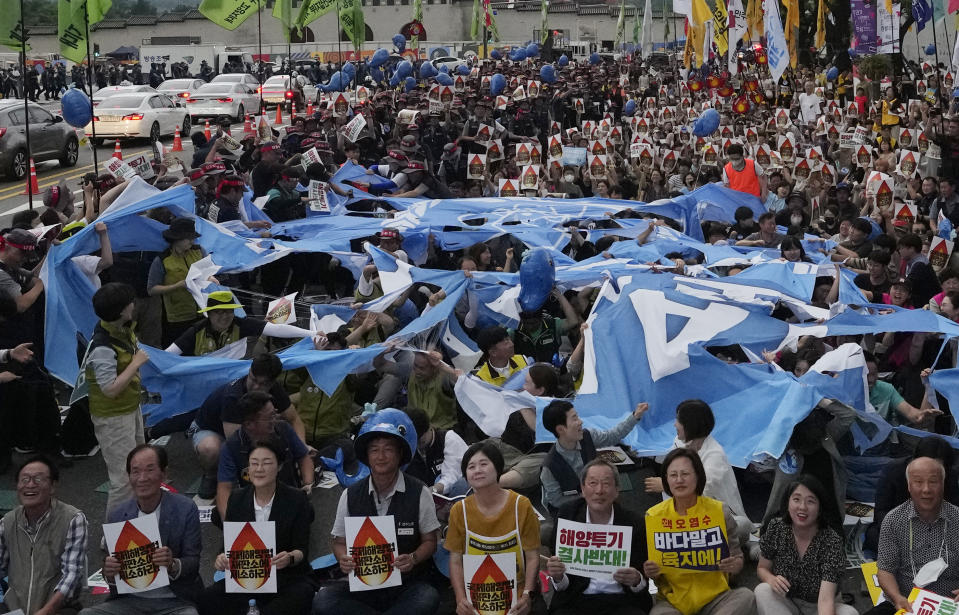 Protesters tear apart a flag symbolizing IAEA (International Atomic Energy Agency) during a rally against the Japanese government's decision to release treated radioactive water from the damaged Fukushima nuclear power plant, in Seoul, South Korea, Saturday, July 8, 2023. (AP Photo/Ahn Young-joon)