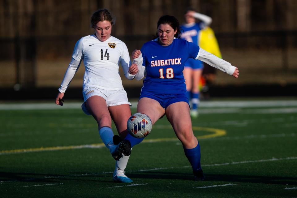 Hamilton's Madelyn Stoel tries to keep posession of the ball against Saugatuck's Mia Zerfas Monday, March 27, 2023, at Saugatuck High School. 