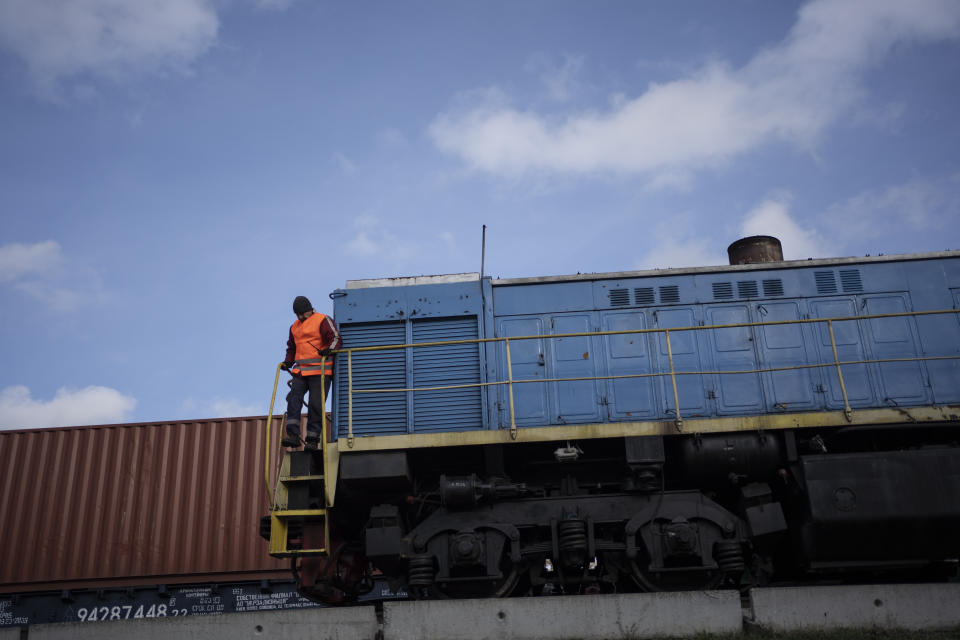 A worker stands on a train, loaded with grain, at a handling and storage facility in central Ukraine, Friday, Nov. 10, 2023. In recent months, an increasing amount of grain has been unloaded from overcrowded silos and is heading to ports on the Black Sea, set to traverse a fledgling shipping corridor launched after Russia pulled out of a U.N.-brokered agreement this summer that allowed food to flow safely from Ukraine during the war. (AP Photo/Hanna Arhirova)