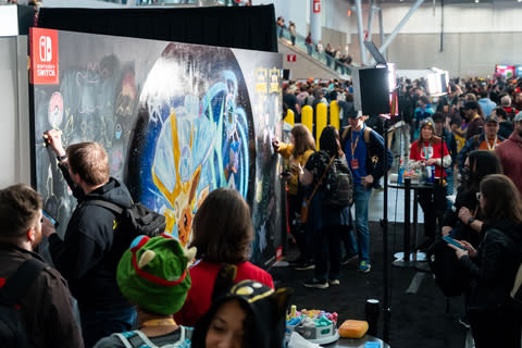 In this photo provided by Nintendo of America, fans gather to view a mural featuring the 