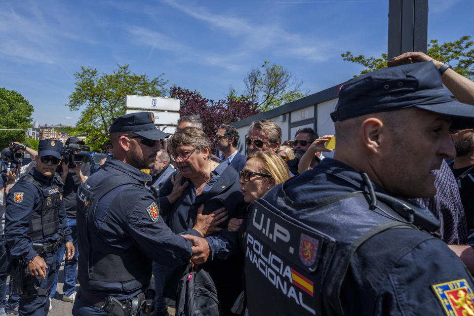 People confront with police officers as they gather outside San Isidro Cemetery in Madrid, Spain, Monday, April 24, 2023. The body of Jose Antonio Primo de Rivera, the founder of Spain’s fascist Falange movement, is exhumed from a Madrid mausoleum and transferred to a city cemetery. (AP Photo/Manu Fernandez)