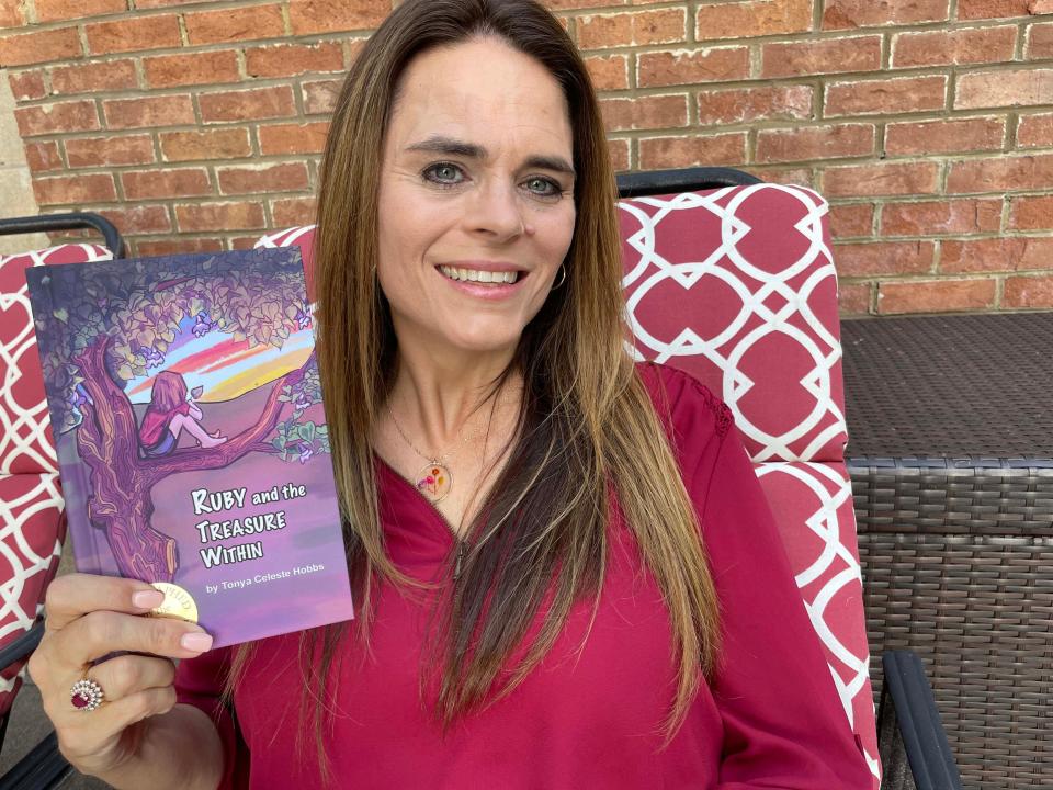 Hardin Valley author Tonya Celeste Hobbs shows off her first book of a series at her home Tuesday, May 10, 2022.