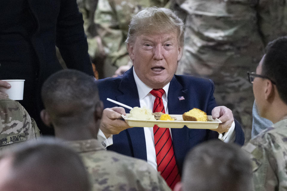 President Donald Trump holds up a tray of Thanksgiving dinner during a surprise Thanksgiving Day visit to the troops, Thursday, Nov. 28, 2019, at Bagram Air Field, Afghanistan. (AP Photo/Alex Brandon)