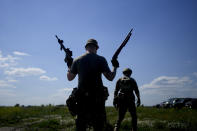 A civilian militia man holds a shotgun and a rifle during training at a shooting range in outskirts Kyiv, Ukraine, Tuesday, June 7, 2022. (AP Photo/Natacha Pisarenko)